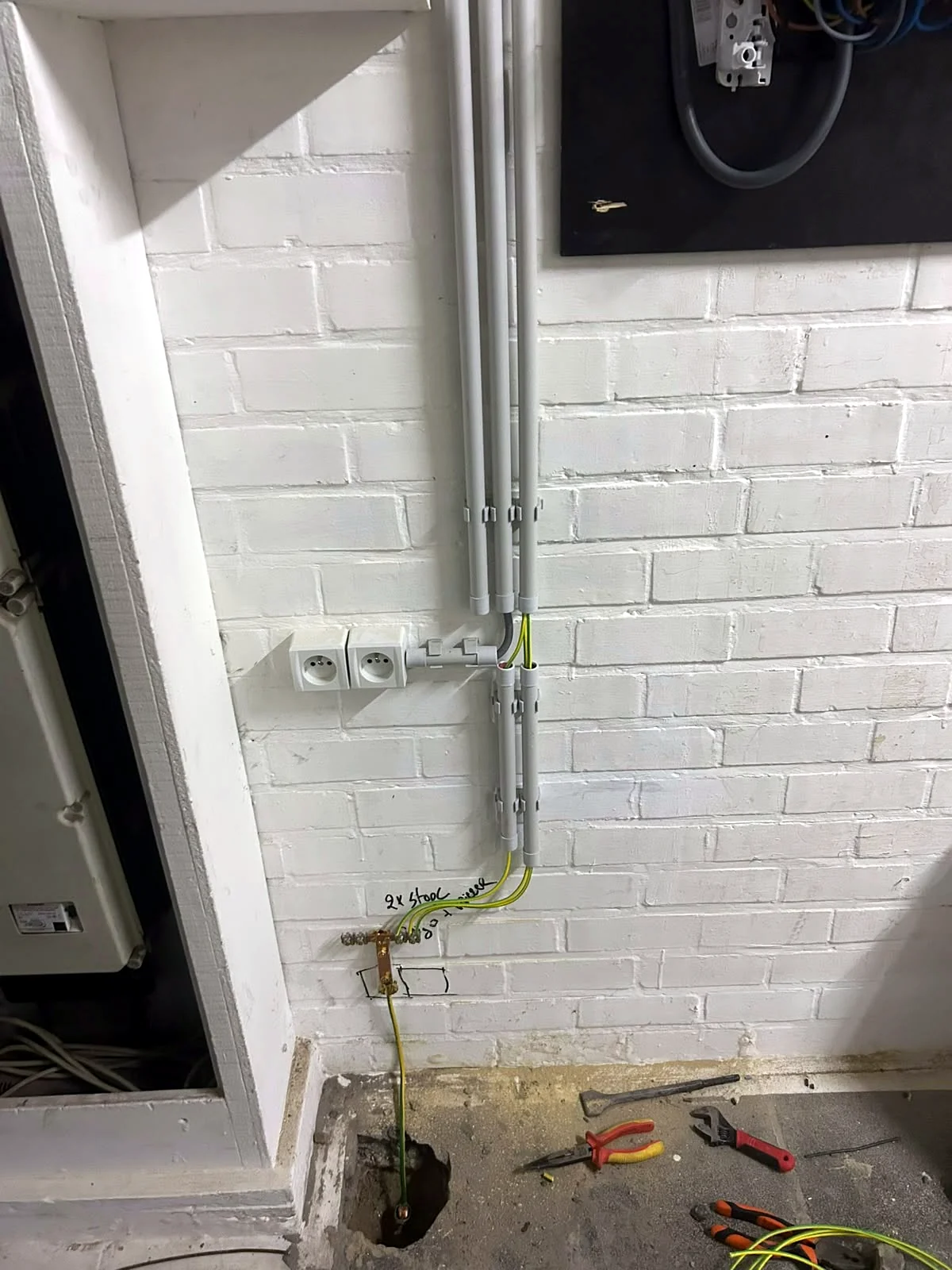 Strak geplaatste opbouwbuizen met stopcontacten in een bijgebouw
